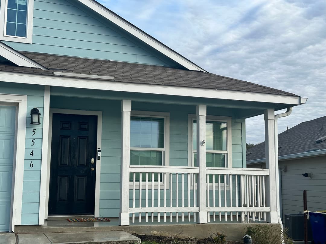 Light blue house exterior with porch, black front door, and house number 5546.